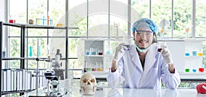 A successful male chemist is examining his new innovation in a laboratory.