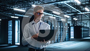 Successful Male Data Center IT Specialist Look Attentively at Laptop Computer Screen, while Work w