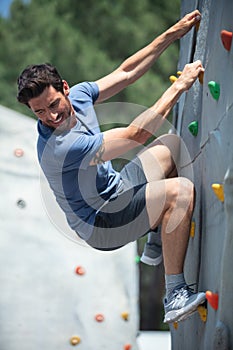successful man climbing on climbing wall