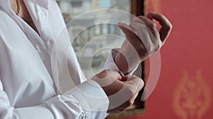 A successful man fastens buttons on his shirt, close-up.