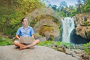 Successful man with laptop in a jungle