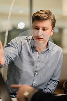 Successful man office worker looks at colleagues during work process in office