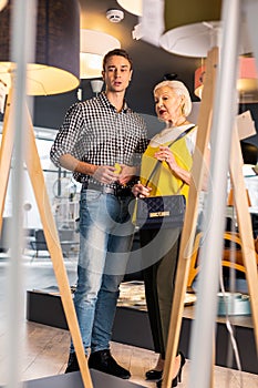 Successful man over 25 having conversation with fashionable aging lady