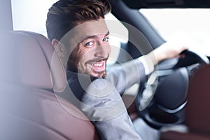 Successful man sitting behind the wheel of a prestigious car