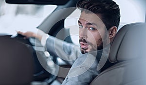 Successful man sitting behind the wheel of a prestigious car