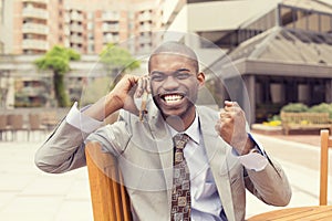 Successful man talking on mobile phone receiving good news