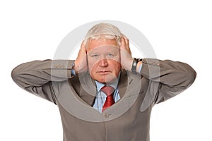 Successful mature businessman covering ears