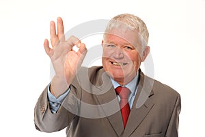 Successful mature businessman giving okay sign