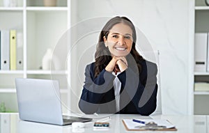 Successful mature businesswoman sitting at office, using laptop