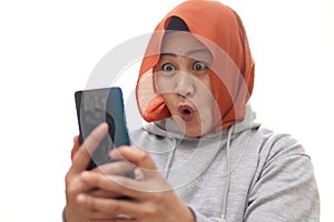 Successful muslim Asian woman surprised amazed smiling while reading message text good news on her smart phone