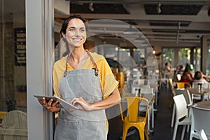 Successful owner standing at cafe entrance