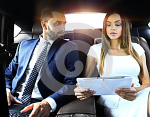 Successful people working together in back seat of car