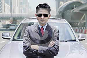 Successful person standing in front of car