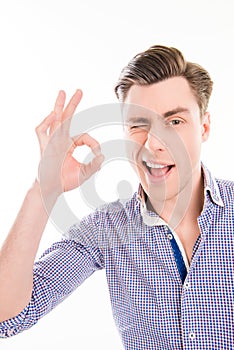 Successful pretty young businessman gesturing `OK` and winking