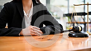 Successful and professional Asian female lawyer sits at her office desk. cropped