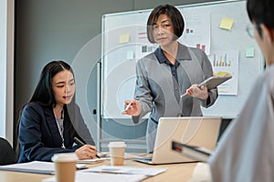 A professional senior Asian female boss is leading the meeting and briefing a new project