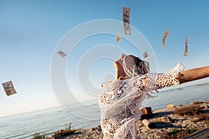 Successful prosperous freelancer throwing her money in the air