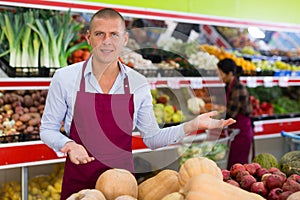 Successful salesman inviting to fruit and vegetable store