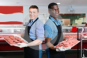 Successful sellers of butcher store offering fresh raw meat steak cutlets