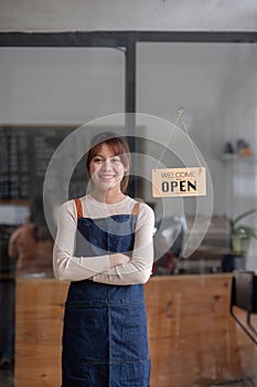 Successful small business owner. Beautiful girl with apron holding tablet standing in coffee shop restaurant. Portrait