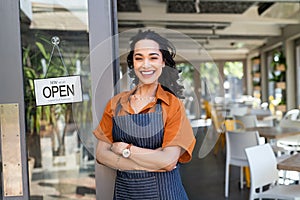 Successful small business owner standing at cafe entrance