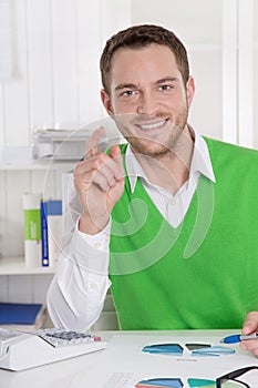 Successful smiling business man sitting at desk.