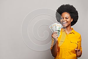 Successful smiling young black woman holding American dollars money on white background