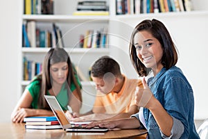 Successful spanish female student with group of learning students