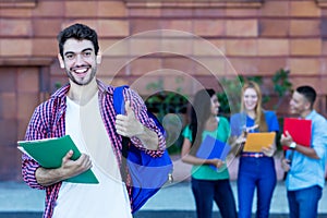 Successful spanish male student with group of students