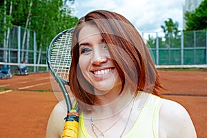 Successful sportswoman with racket at the tennis court. Healthy lifestyle.