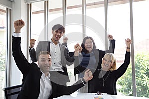 Successful startup entrepreneurs and business people team achieving goals celebrating giving high five in office.