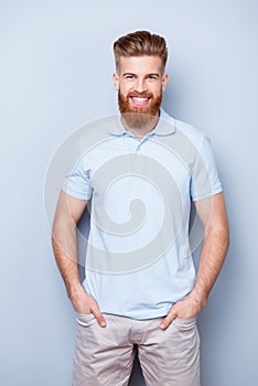 Successful stylish young red bearded man in casual wear is stand