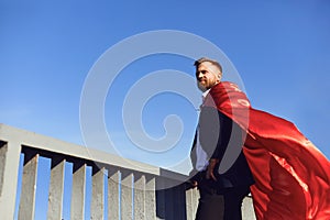 Successful superhero businessman on a background of blue sky