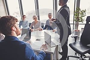 Team leader and business owner leading informal in-house business meeting