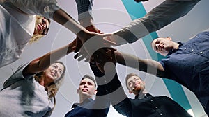 Successful team in office: many hands holding together standing in circle. Team building concept.