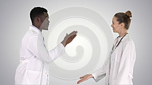 Successful team of surgeons giving high five and laughing wall on gradient background on gradient background.