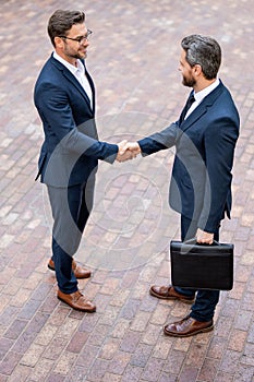 Successful teamwork. Business people shaking hands. Business men in suit shaking hands outdoors. Business idea. Business