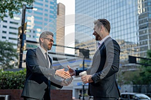Successful teamwork. Business people shaking hands. Business men in suit shaking hands outdoors. Handshake. Two business
