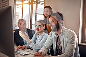 Successful teamwork-smiling business workers cheering