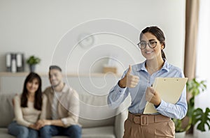 Successful therapy. Happy arab psychologist showing thumb up gesture during session with loving couple at office