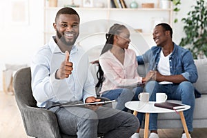 Successful Therapy. Psychologist Gesturing Thumb Up While Happy Couple Bonding On Couch