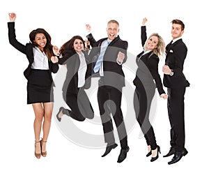 Successful welldressed businesspeople with arms raised