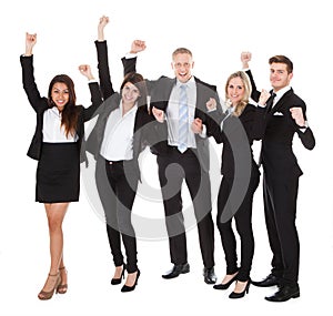 Successful Welldressed Businesspeople With Arms Raised