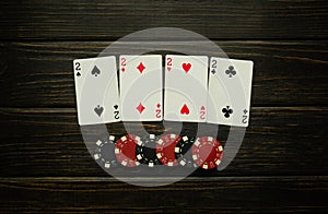 Successful win with four playing cards in club. Poker game with four of a kind or quads combination on black table photo