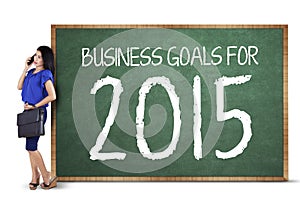 Successful woman with a business goals board