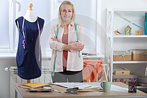 A successful woman designer clothes, tailor in the studio in full growth. Beautiful European woman looking at the camera photo