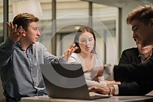 Successful woman office worker looks at colleagues during work process in office