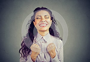 Successful woman winning with fists pumped celebrating success