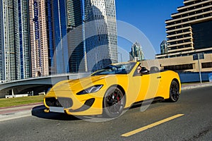 Successful yang businessman in yellow cabrio car.