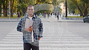 Successful young afro american business man guy african student in sunglasses stands in city street walking crosswalk